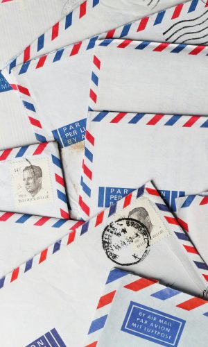 A close-up of vintage airmail envelopes with stamps and postmarks, showcasing nostalgic design.